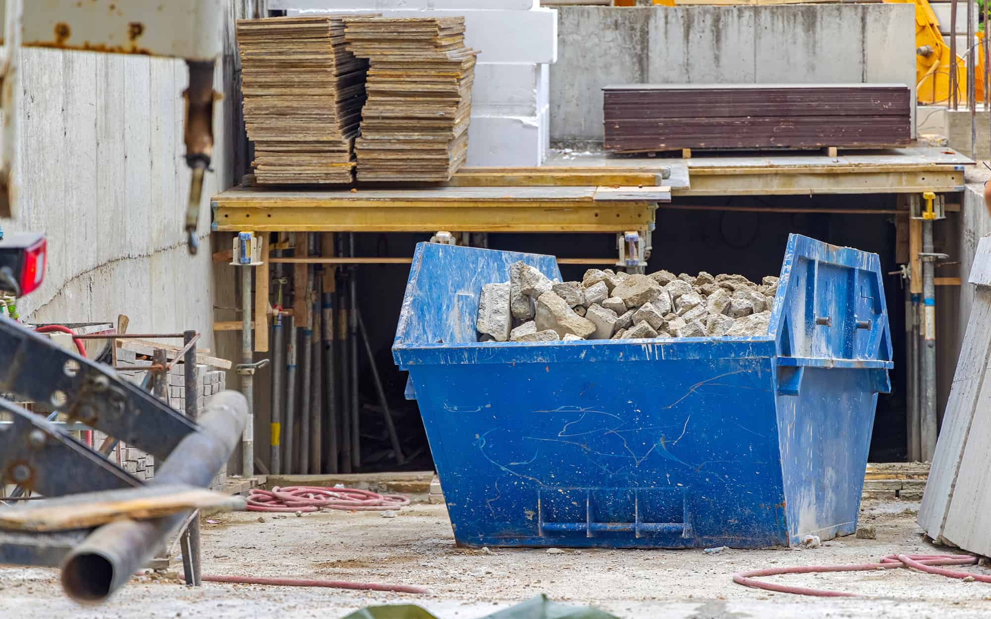 Innovative Debris Management Solutions for Construction and Roofing Projects 1 Front view of a container full of construction debris at a construction site